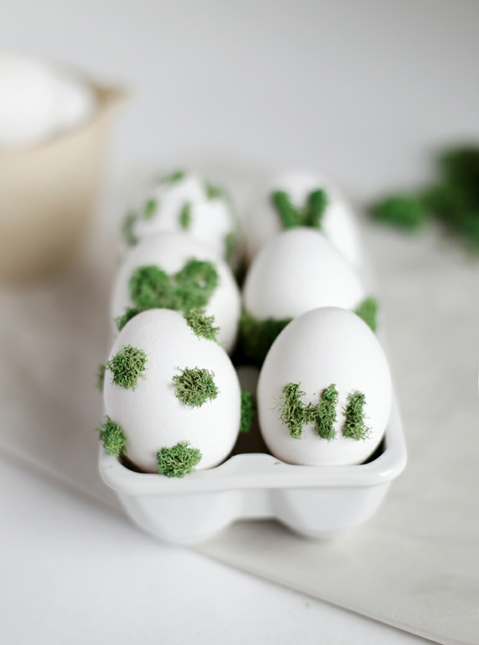 Eier bemalen mit Moos, kleine grüne Flecken und das Wort Hi mit Moos geschrieben