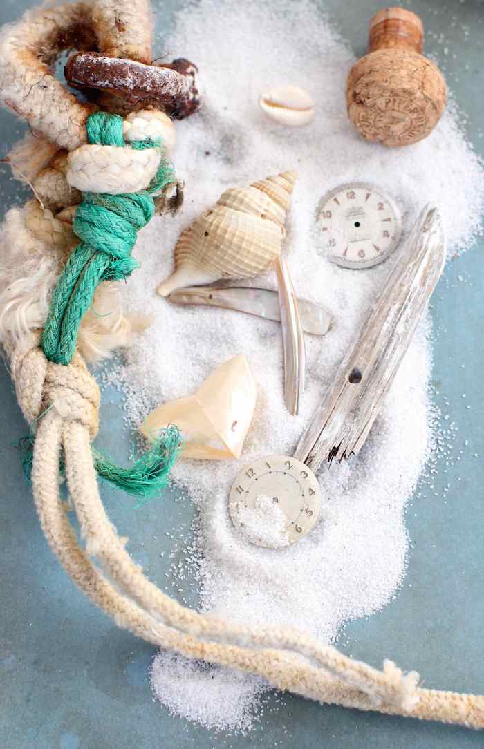 Materialien für sommerliches Hochzeitsgeschenk, Sand und Muscheln in dursichtige Weihnachtskugel füllen