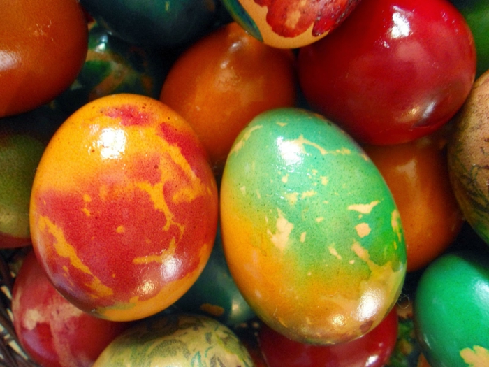 glätzende Ostereier, bunte Ostereierfarbe, ein Haufen von gefärbten Eiern