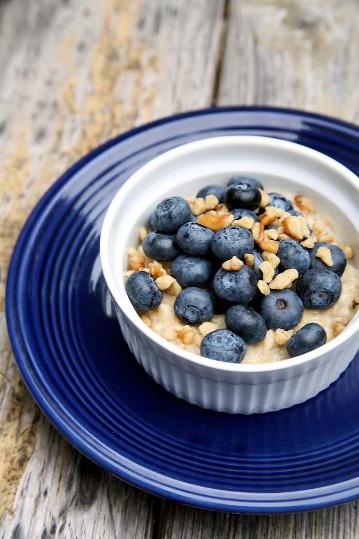 porridge rezept kalorienarm, ein dunkelblauer teller, frühstück mit quinoa und blaubeeren