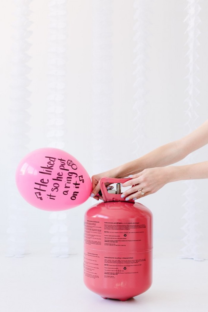 Rosa Luftballon mit Helium füllen, Botschaft mit schwarzem Permanentmarker aufschreiben