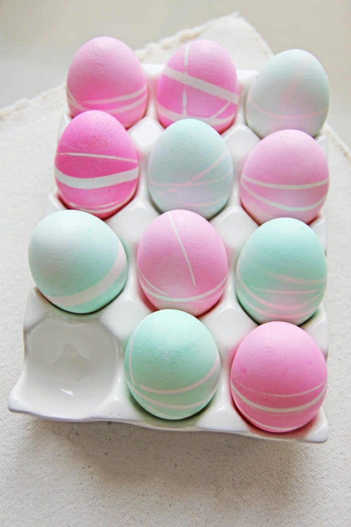 rosa und blaue Eier mit kleinen Linien von Klebeband, Ostereier anmalen