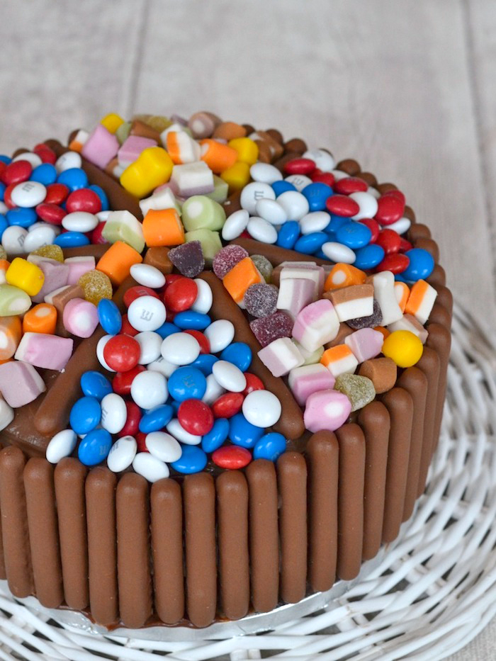 süßigkeiten kuchen dekoriert mit schokoladenriegel und bunten bonbons, geleebonbons