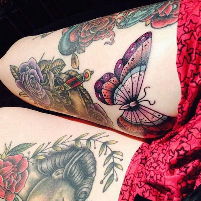 tattoo ideen frauen, frau mit vielen bunten tätowierungen an den beinen, großer schmetterling, lila rose