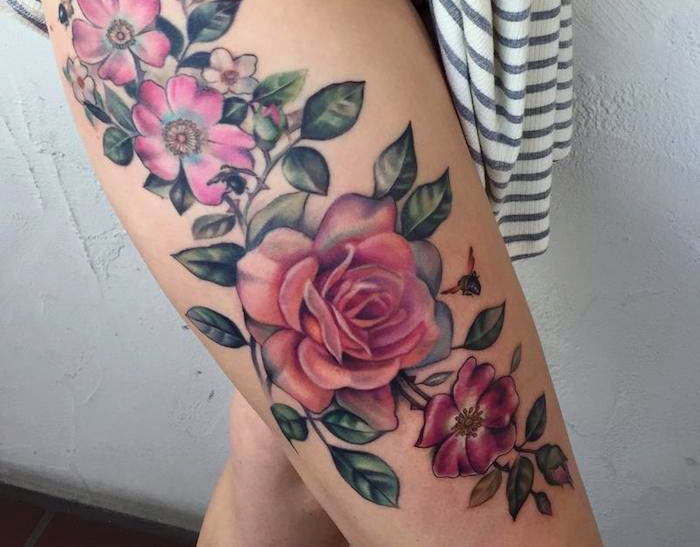 tattoo ideen frauen, große realistische tätowierung mit blumen-motiv, rosa blumen am oberschenkel