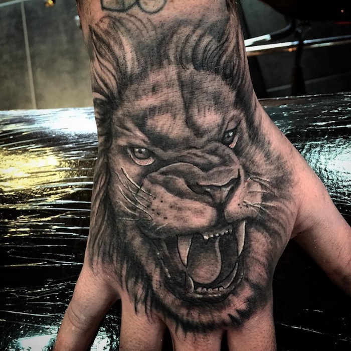 tattoo löwe, hand tätowieren, shwarz-graue tätowierung mit löwen-motiv