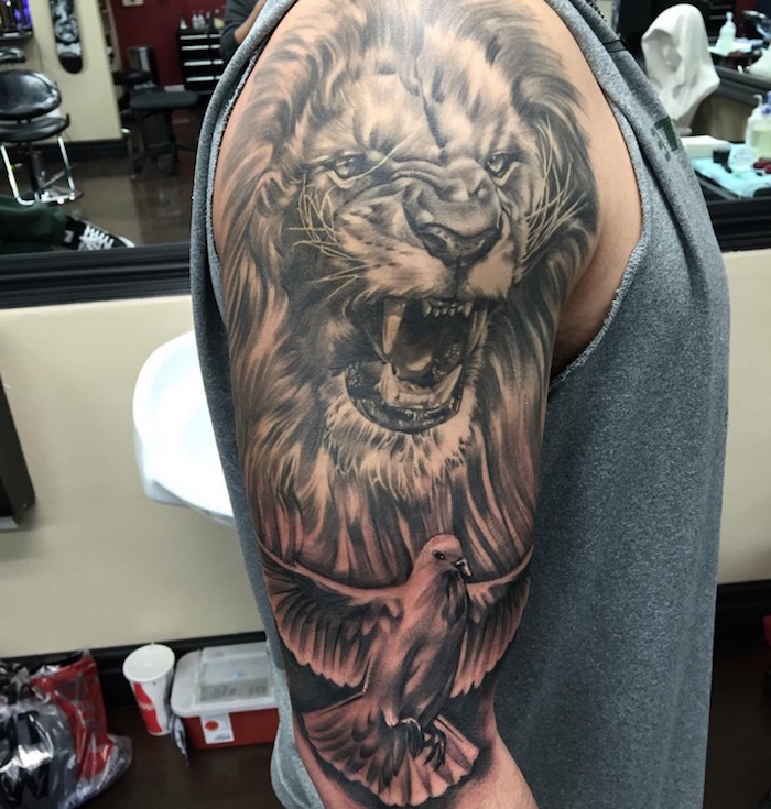 tattoo löwe, mann mit großer realistischer 3d-tätowierung am arm, läwe mit weißer taube