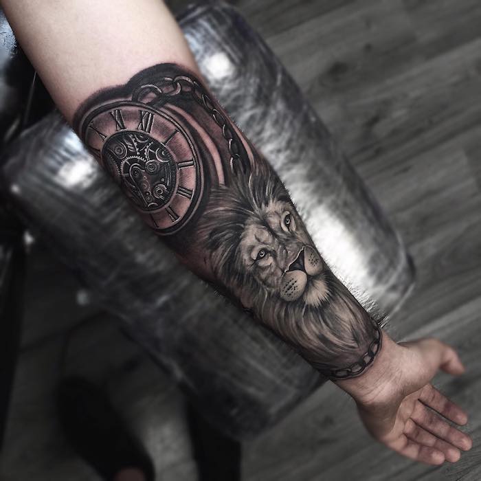 tattoo löwenkopf, realitische tätowierung am unterarm, löwe mit großem kompass