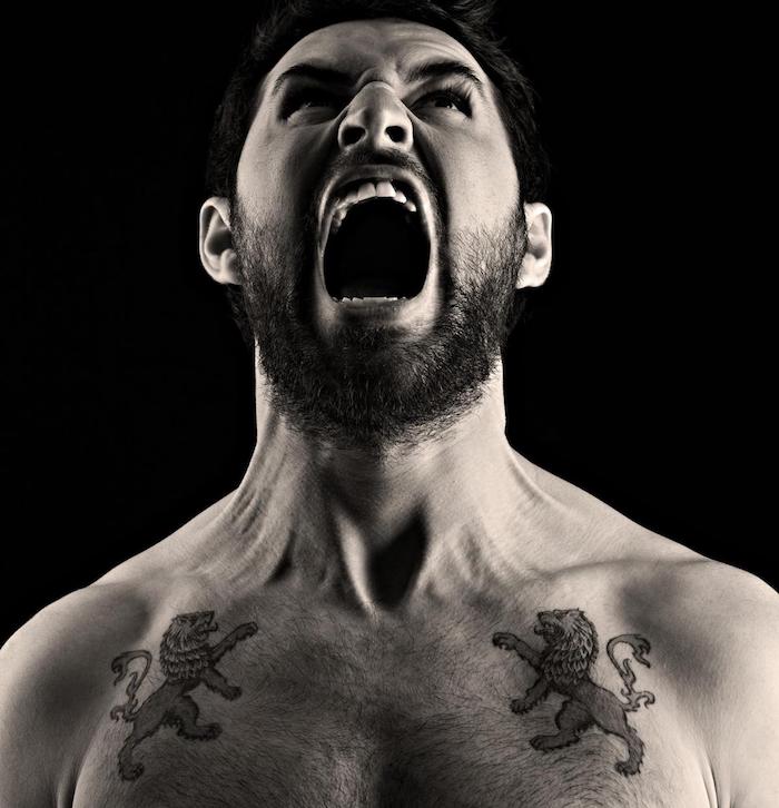 tattoo löwenkopf, mann mit zwei tätowierungen an der brust, schwarz-graue tattoos