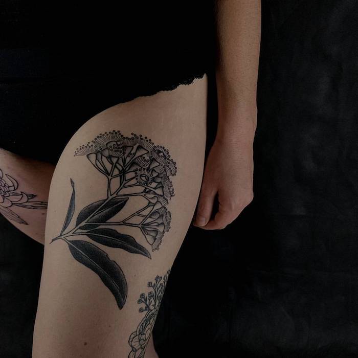 tattoo vorlagen frauen, frau mit großer schwarz-grauer tätowierung am oberschenkel