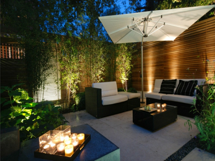 moderne terrassen am abend zum sitzen und entspannen, glas wein, bequemes sofa, kerzen, aromakerzen