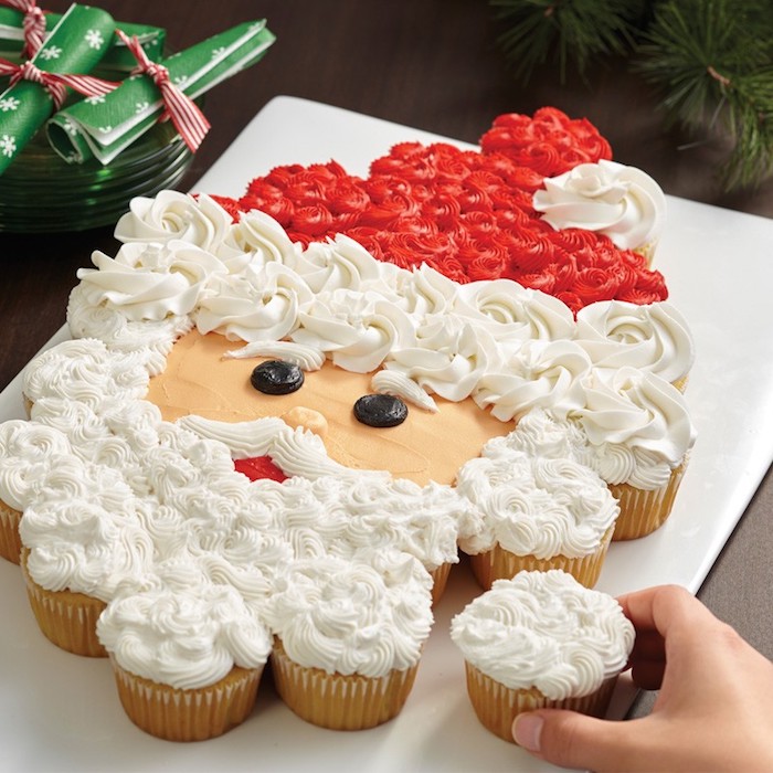torte aus süßigkeiten für weihnachten, weihnachtsmann aus cupcakes, weiße und rote sahne