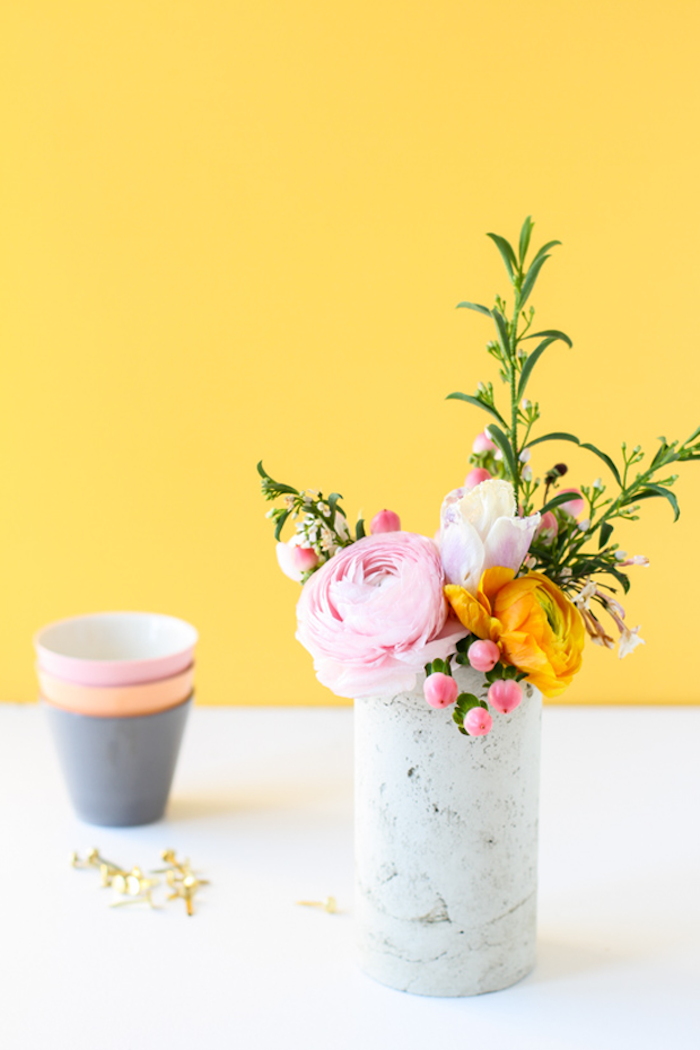 Ranunkel in weißer Vase, kleiner Blumenstrauß für fröhliche Frühlingsstimmung zu Hause