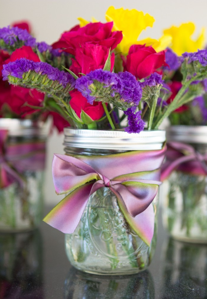 Vase aus Einmachglas selbst gestalten, mit lila Dekoband verzieren, kleiner Blumenstrauß