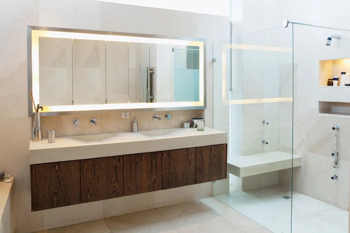 badezimmer mit einem großen spiegel und einmem waschbecken 