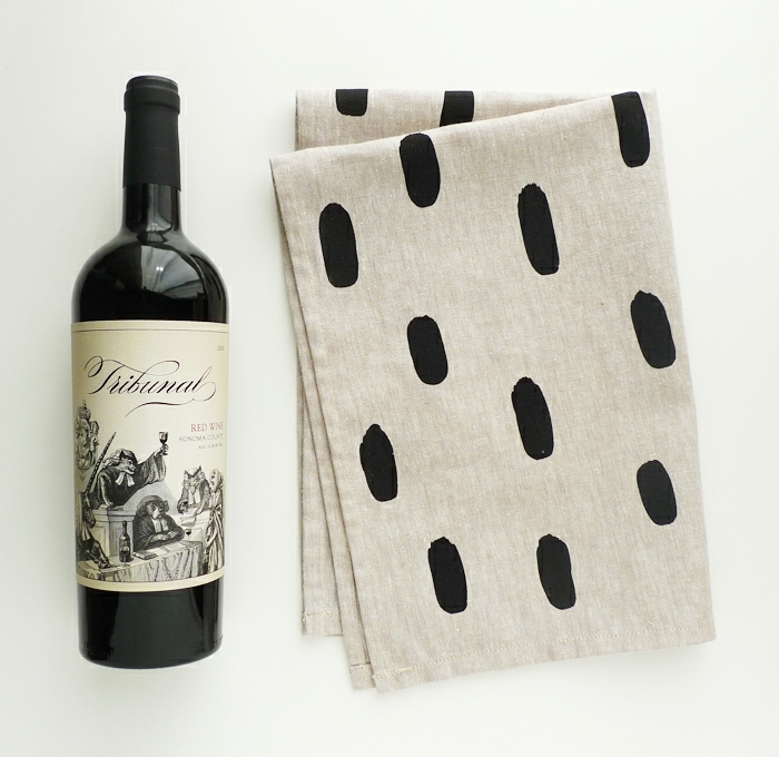 eine Weinflasche verpacken mit einem grauen Tuch auf schwarzen Flecken