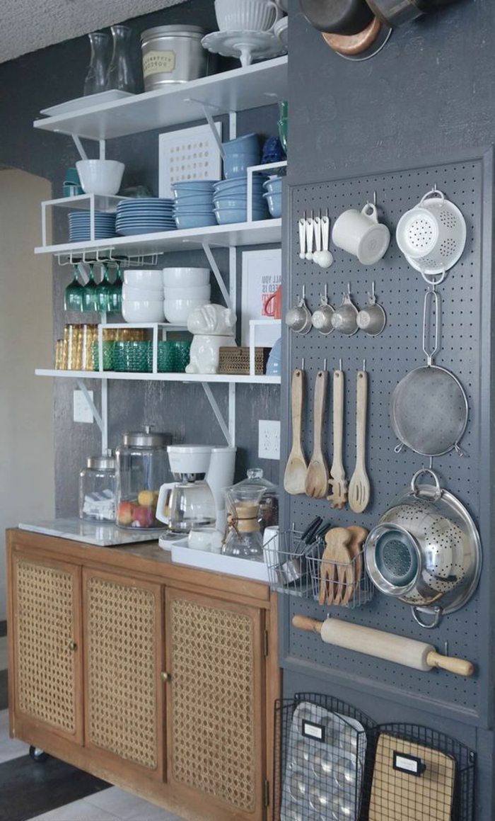 Wandgestaltung Küche mit gehängtem Küchenzubehör, Geschirr auf Regalen, blaue Wand