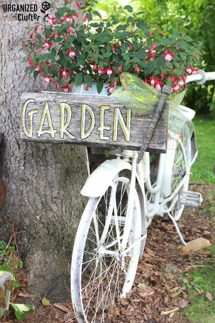 ein Aufschrift Garten auf hölzerner Tabelle, ein alter Fahrrad in weißer Farbe gestrichen, Garten gestalten mit wenig Geld