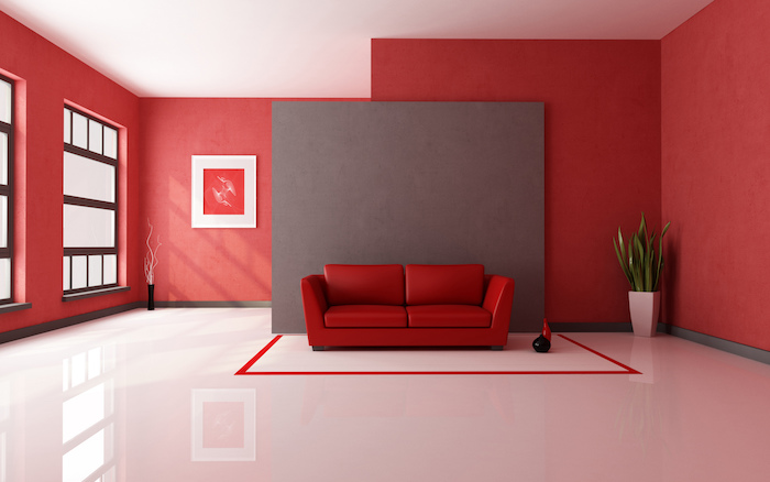 ein sofa mit roten kissen, eine wohnung einrichten, ein wohnzimmer mit großen roten wänden und weißen fenstern und einer großen weißen vase mit grünen pflanten und mit einem roten bild