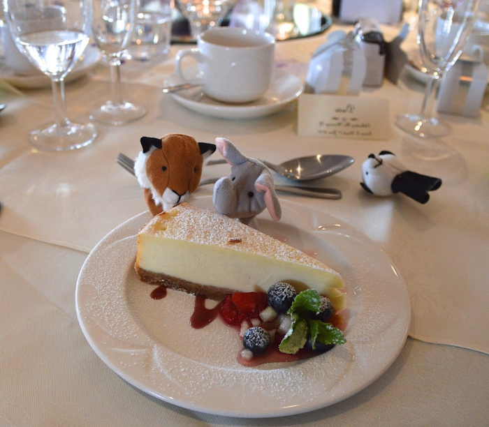 ein Stück süße Torte, kleine Kuscheltier wie Löwen, Elefanten und Panda, Kommunion Tischdekoration