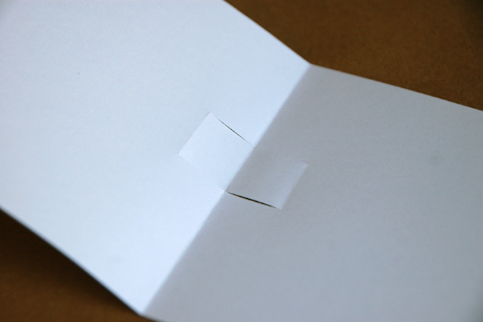 tusch aus holz und eine kleine weiße gefaltete pop upkarte aus papier, eine pop up karten anleitung, basteln mit papier
