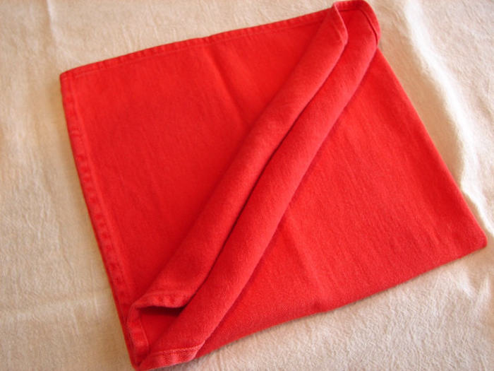 eine große rote gefaltete serviette und eine weiße decke, servietten falten einfach und wirkungsvoll 