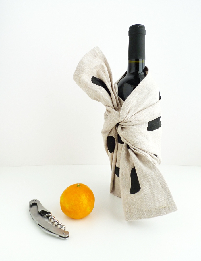 ein Korkenzieher, eine Orange und eine verpackte Weinflasche, Flasche verpacken