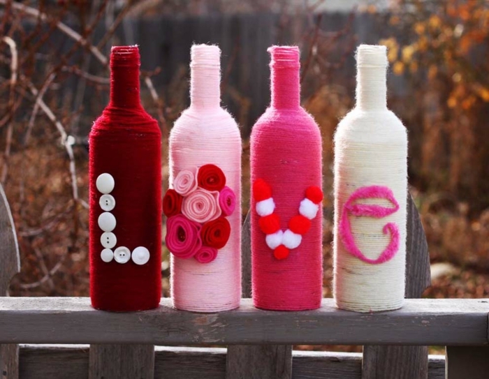 die vier Flaschen die die Aufschrift Love formen sind auf einer Terrasse, Flasche als Geschenk verpacken
