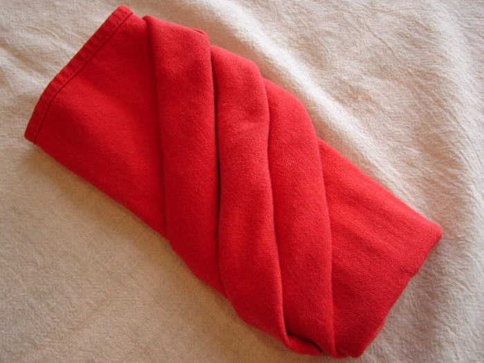 eine weiße decke und eine rote gefaltete bestecktasche, servietten falten hochzeit, tischdeko ideen