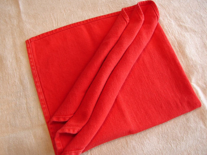 weiße decke und eine gefaltete rote bestecktasche, tischdeko selber basteln, eine rote bestecktasche basteln