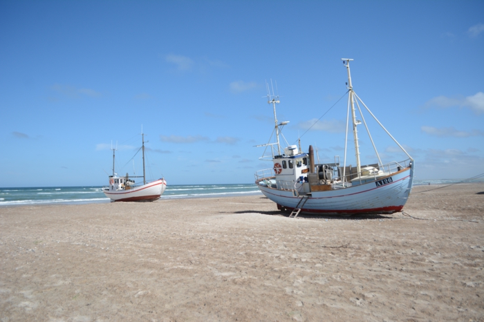 Boote am Strand, blauer Himmel und weißer Sand an der dänischen Nordseeküste