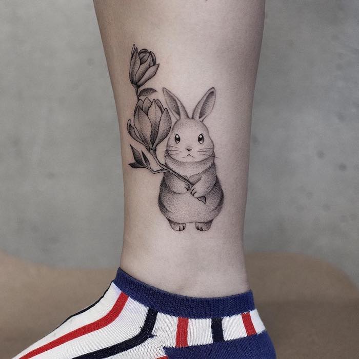 Zartes Tattoo Motiv, Kaninchen mit Blume, Tattoo Ideen für Frauen