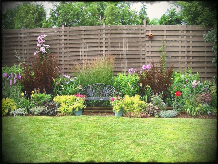 ein Garten voller Symmetrie, hoher Sichtschutz aus Holz, ein gepflegter Rase, Garten anlegen günstig