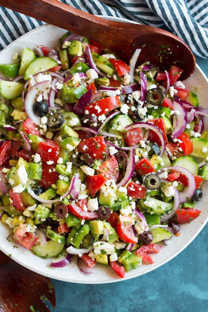 ein bunter, gemischter Salat aus Tomaten, Gurken, Avocado, Zwiebel und Oliven, leckere Salate zum Abnehmen