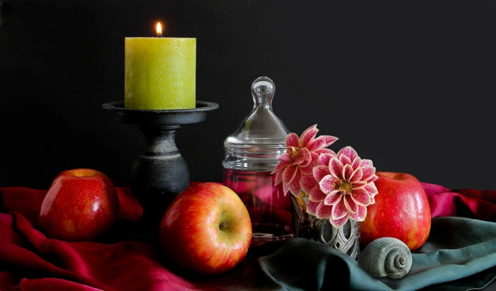eine gelbe Kerze, kleine Äpfel, eine Vase mit rosa Blumen, Tischdeko Kommunion