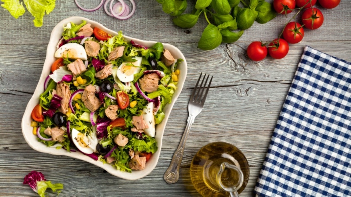 schnelle Salate von Eier und Fleisch mit Gemüse in quadratem Teller