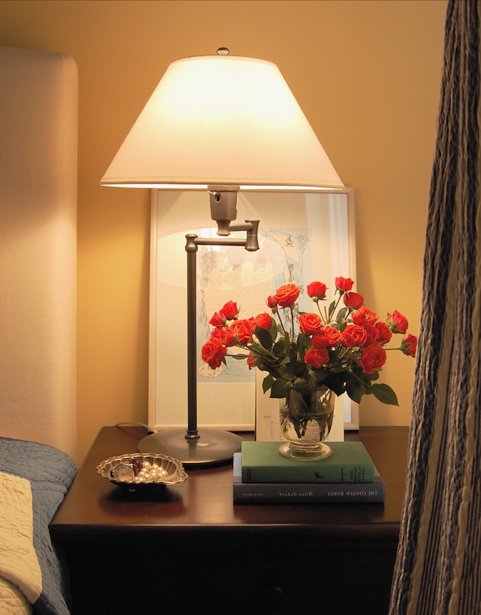 schlafzimmer dekorieren, neben dem bett soll ein kleiner schrank stehen, bücher darauf, frische rosen, lampe