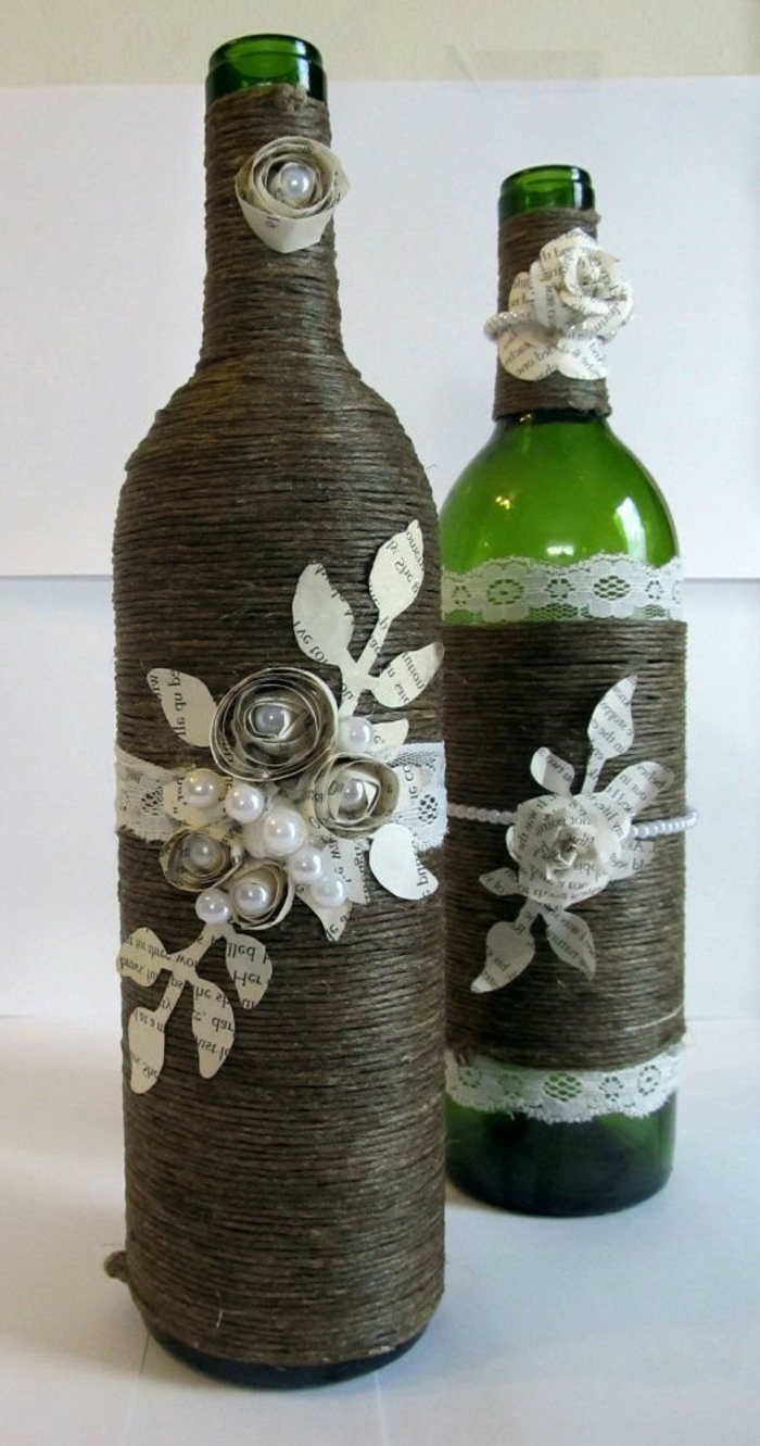 zwei Flaschen mit Ornamenten als Dekoration, kleine Blumen aus Papier und Spitze, Flasche einpacken