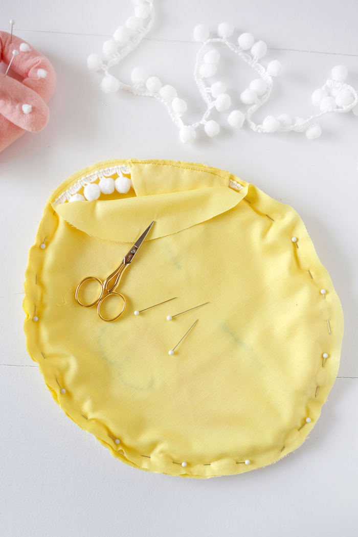 Süßes Kissen fürs Kinderzimmer selber nähen, aus gelbem Stoff, weiße Pompons