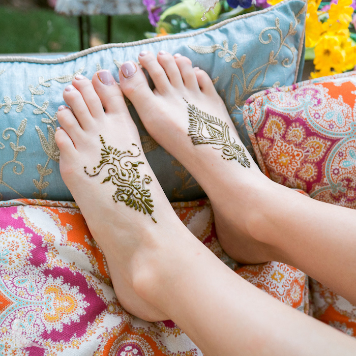 Henna Tattoos an den Füßen, bunte Deko Kissen, Nagellack in Pastellton
