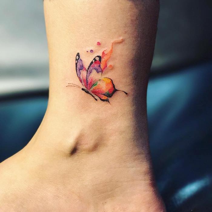 Farbiges Tattoo am Knöchel, kleiner Schmetterling, zarte weibliche Tattoo Motive