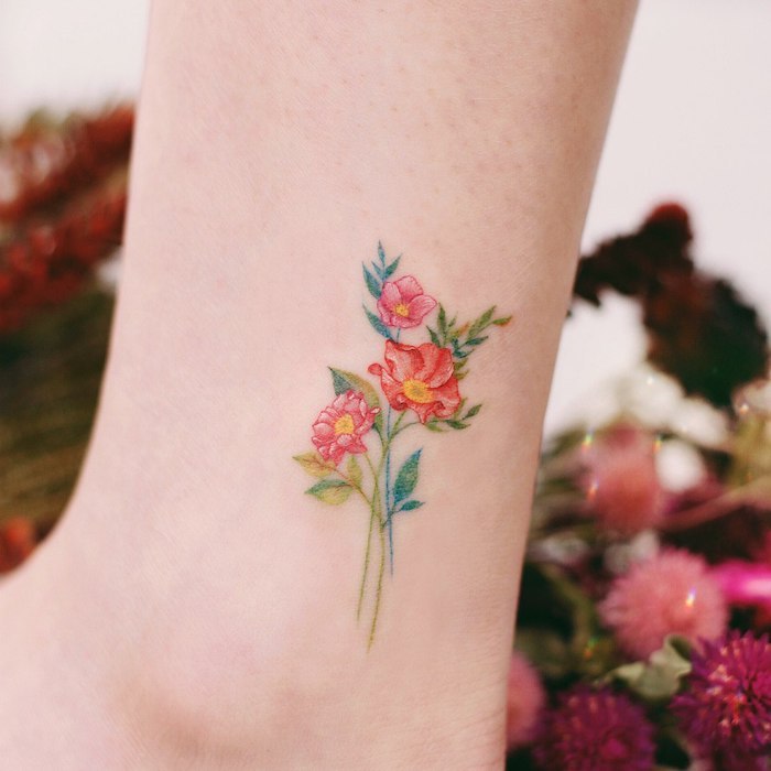 Kleines Tattoo am Bein, drei rote Blumen, kleiner Blumenstrauß, farbiges Tattoo