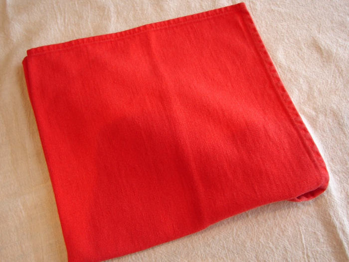 eine weiße decke und eine kleine rote serviette, eine bestecktasche falten, eine tischdekoration selber basteln