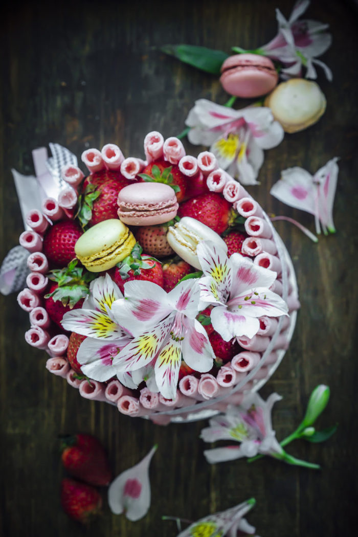 Tortendekoration aus Erdbeeren Lilien und französischen Macarons