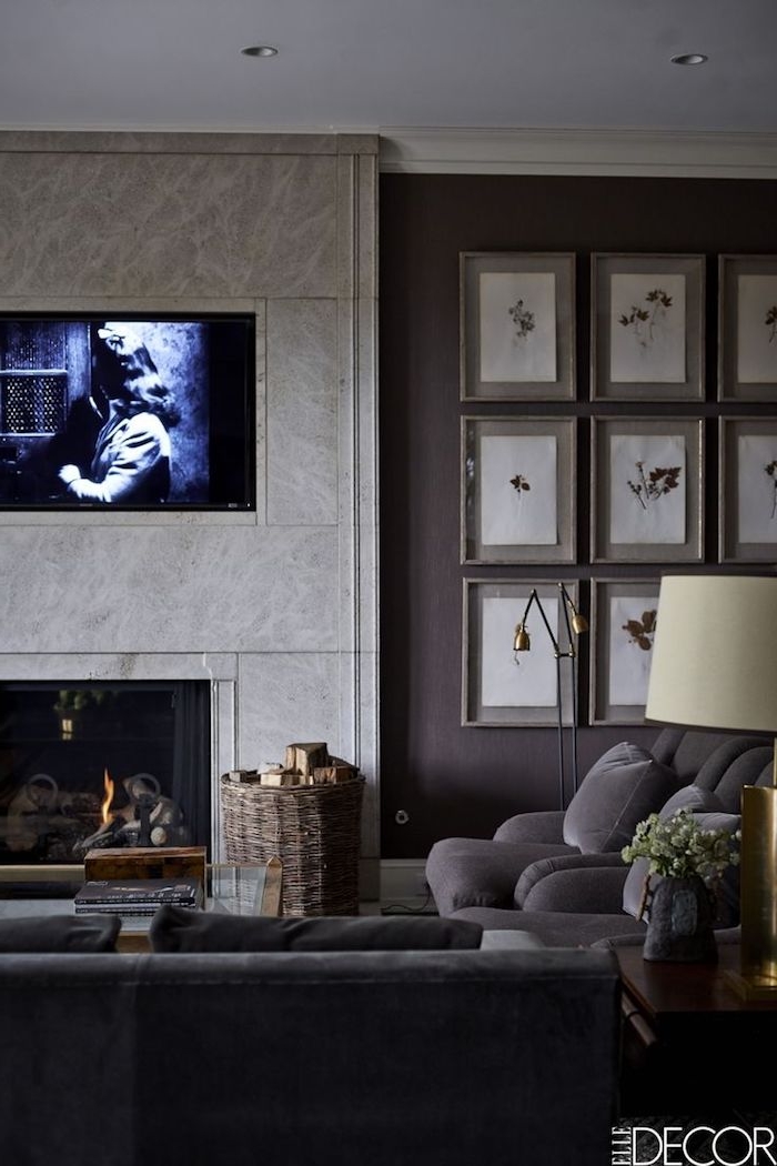 wohnzimmer in grau und Schwarz, Kamin und Fernsehwand, Korb aus Rattan, Bilder an der Wand