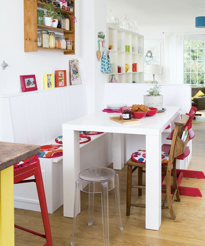 ein weißer Tisch mit roten Kissen, kleines Esszimmer, kleine Wohnung einrichten
