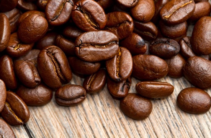 wie wachsen haare schneller, kaffee verwenden, viele kaffeebohnen auf hölternem tisch, haarwachstum