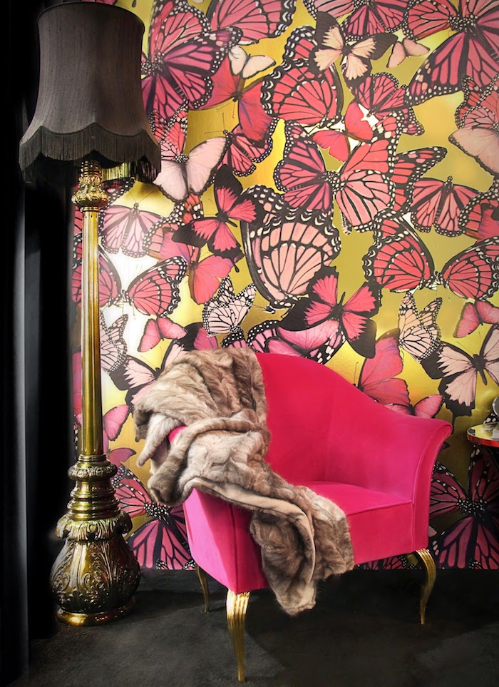 Auffällige Tapete, rosa Schmetterlinge auf gelbem Grund, schwarze Stehlampe, violetter Sessel mit Pelz