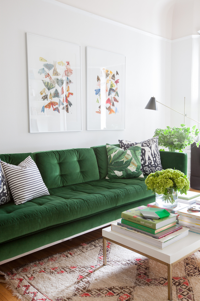 Wohnzimmer Einrichtung, dunkelgrünes Sofa, grüne Zimmerpflanzen, weißer Couchtisch