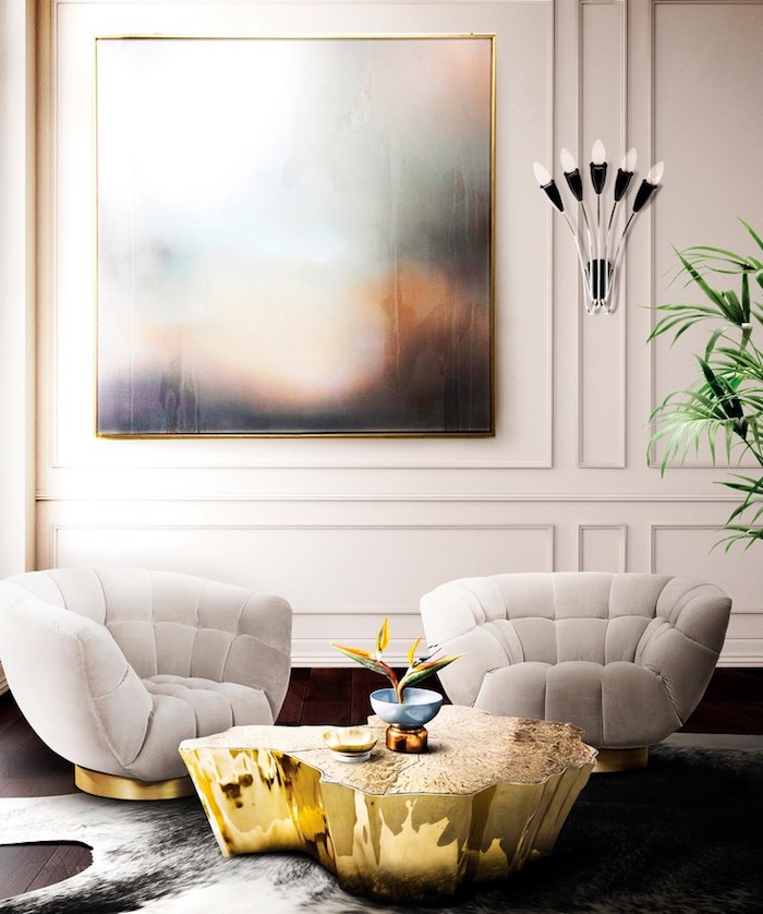 Wandfarbe Weiß, weiße Sessel, niedriger Couchtisch, Wandlampe und grüne Zimmerpflanze